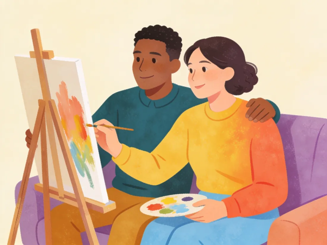 Two friends on a couch looking at an unfinished painting together.